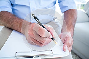 Businessman writing on notepad
