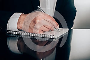 Businessman writing in notepad