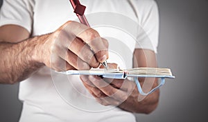 Businessman writing on a notepad in office