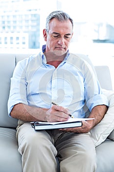 Businessman writing on notepad at office