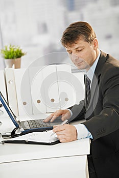 Businessman writing notes to organizer