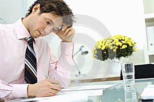 Businessman writing on paper