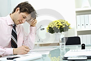 Businessman writing on paper