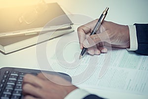 Businessman writing with pen and working in the office