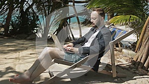 Businessman is writing report on the tropical beach.