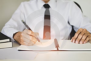 businessman writing and signature on the paper document is working in his office