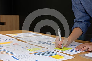 Businessman writing on sticky note on business document. paper r