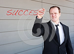 Businessman writing the word success on screen