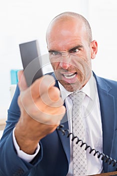 Businessman yelling at his phone