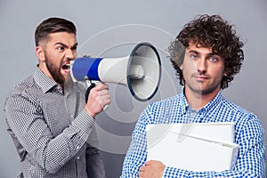 Businessman yelling via megaphone to another man