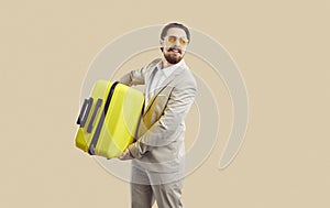 Businessman with yellow travel suitcase goes on business trip or long-awaited vacation.