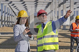 Businessman and Young Female Architect With Digital Tablet Meeting at Construction Site