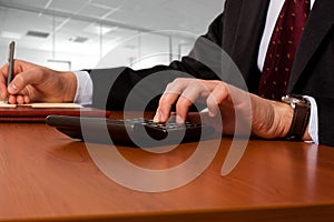 Businessmanworking working with a calculator