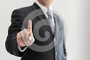 Businessmanâ€™s hand with business manâ€™s pointing finger touching or clicking on screen gesture for company goal