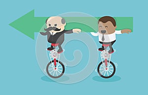 Businessmen and African businessmen riding a bicycle holding green arrow