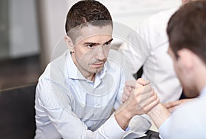 Businessmen arm wrestling in office