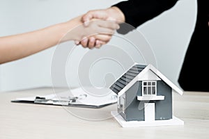 Businessmen and brokers real estate agents shake hands after completing negotiations to buy houses insurance and sign contracts.