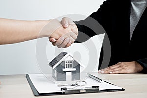 Businessmen and brokers real estate agents shake hands after completing negotiations to buy houses insurance and sign contracts.