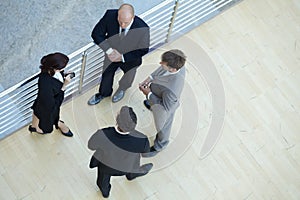 Businessmen and businesswoman standing together by railing