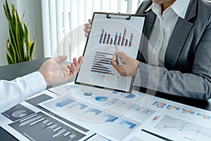 Businessmen and businesswomen team meeting to plan strategies to increase business income. Have a brainstorming graph analysis and