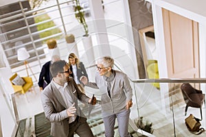 Businessmen and businesswomen walking and taking stairs in an of