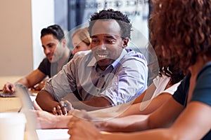 Businessmen And Businesswomen Working In Shared Open Plan Office Workspace