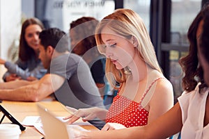 Businessmen And Businesswomen Working In Shared Open Plan Office Workspace