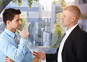 Businessmen chatting outside of office