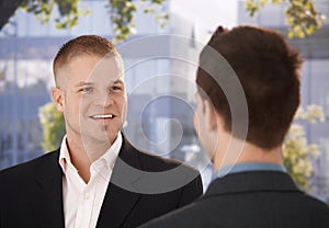 Businessmen chatting outside of office