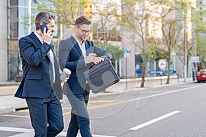 Businessmen communicating at meeting. Two businessmen discussing outdoor during business meeting. Businessmen talking