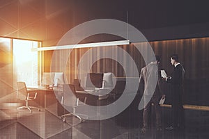 Businessmen in dark wooden office