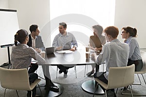 Businessmen discussing business project at multiethnic meeting in conference room