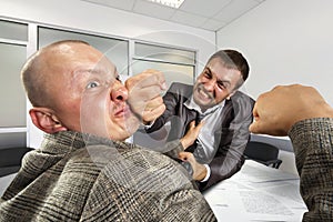 Businessmen fighting in the office