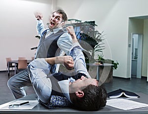 Businessmen fighting in the office