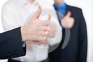 Businessmen gesturing thumbs up