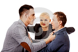 Businessmen getting into a fight woman trying to separate them