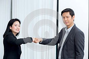 businessmen giving fist bump after business achievement in meeting room.
