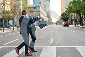 Businessmen go to work. Business taliking. Two businessmen in elegant business suits, walking and talking in city street
