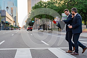 Businessmen go to work. Business taliking. Two businessmen in elegant business suits, walking and talking in city street