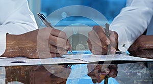 Businessmen hands signing documents on Riyadh skyline city scape background