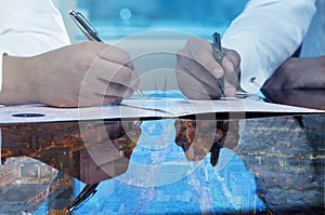 Businessmen hands signing documents on Riyadh skyline city scape background