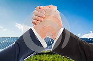 Businessmen handshake as teamwork on solarpower photovoltaic pan