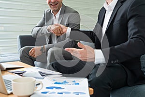 Businessmen handshake business deal in office.