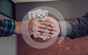 Businessmen handshake with money in hands - corruption concept