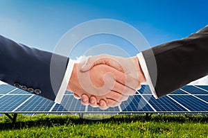 Businessmen handshake on solarpower photovoltaic panel backgroun