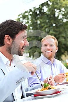 Businessmen having food at outdoor restaurant