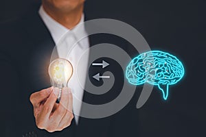 Businessmen hold the light bulb with a brain icon dark background