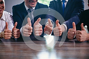 Businessmen holding big thumbs up in a row