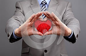 Businessmen is holding out a red heart