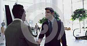 Businessmen interacting with each other in the lobby at office 4k
